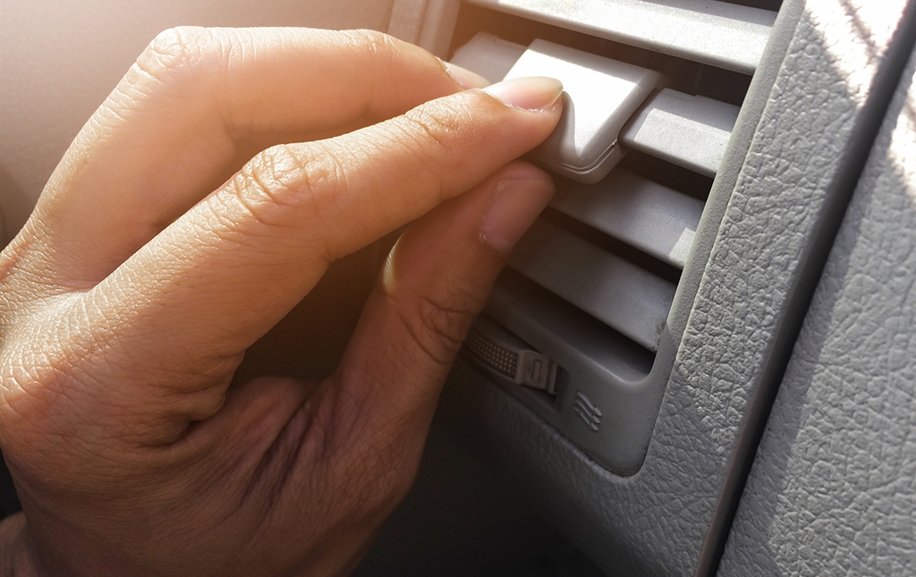 Car drivers adjusts air conditioning of the car